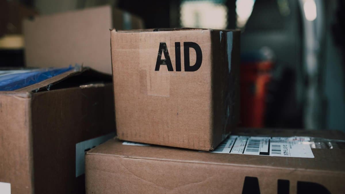 Stacked aid boxes ready for distribution in a delivery vehicle.