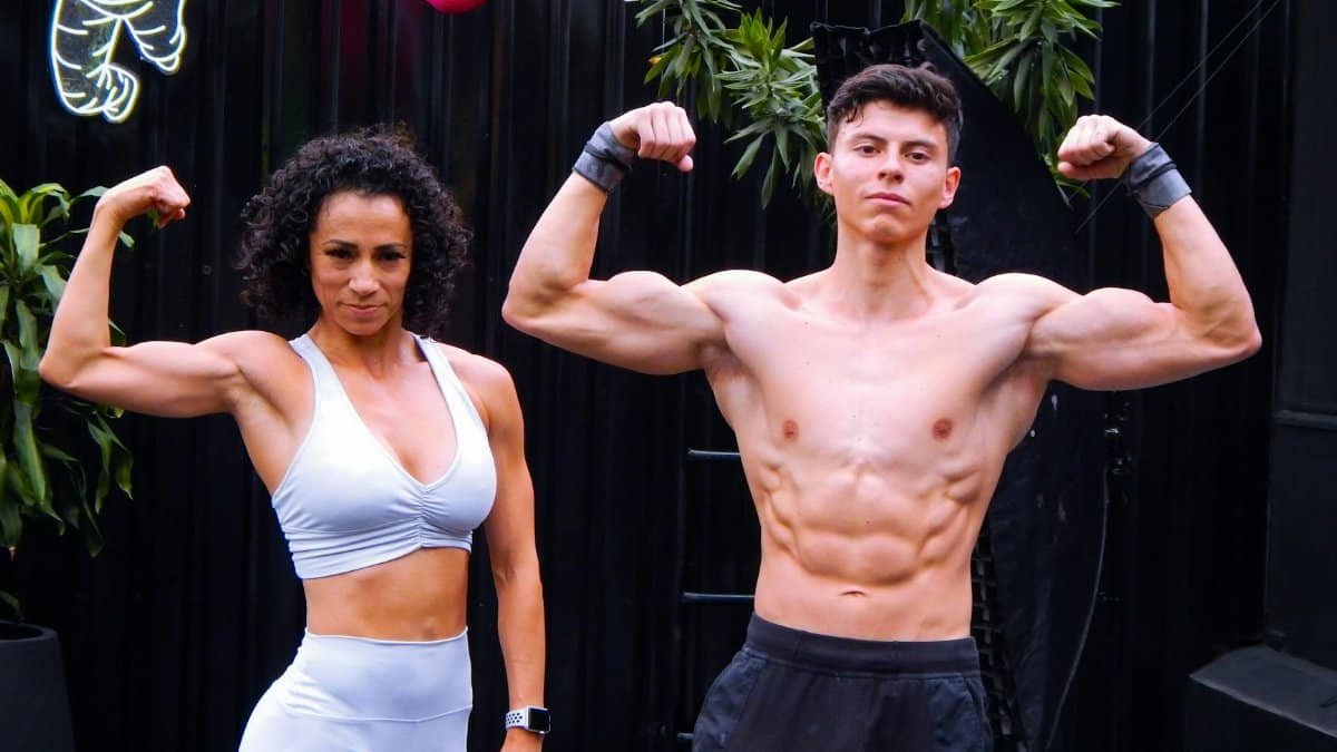 A fit man and woman flex muscles in activewear outdoors in Mexico City.