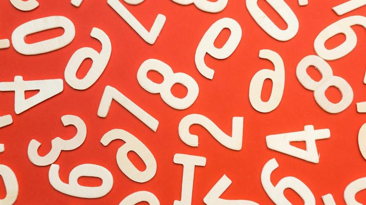 Abstract flat lay of white numbers on red background.