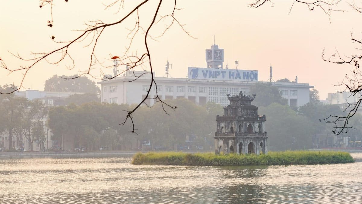 Scenic view of Turtle Tower on Hoan Kiem Lake, Hanoi, with misty morning light.