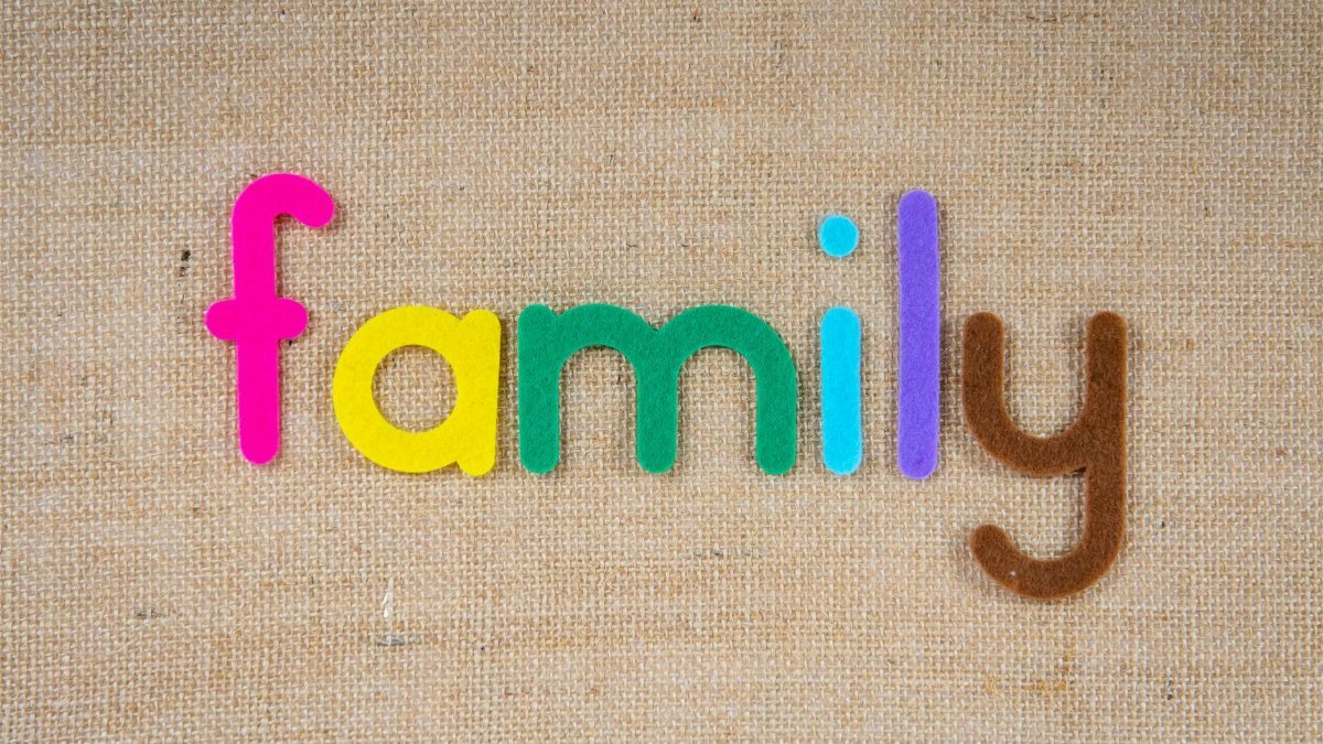 Vibrant letters spelling 'family' on a textured burlap background, emphasizing togetherness.