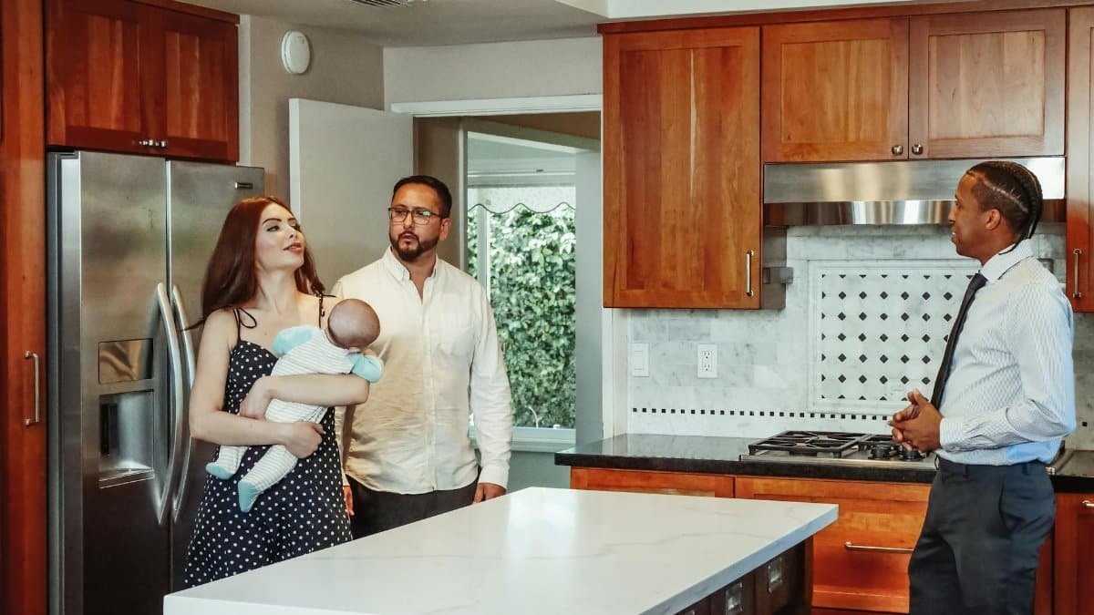 Couple with baby exploring a kitchen with a real estate agent.