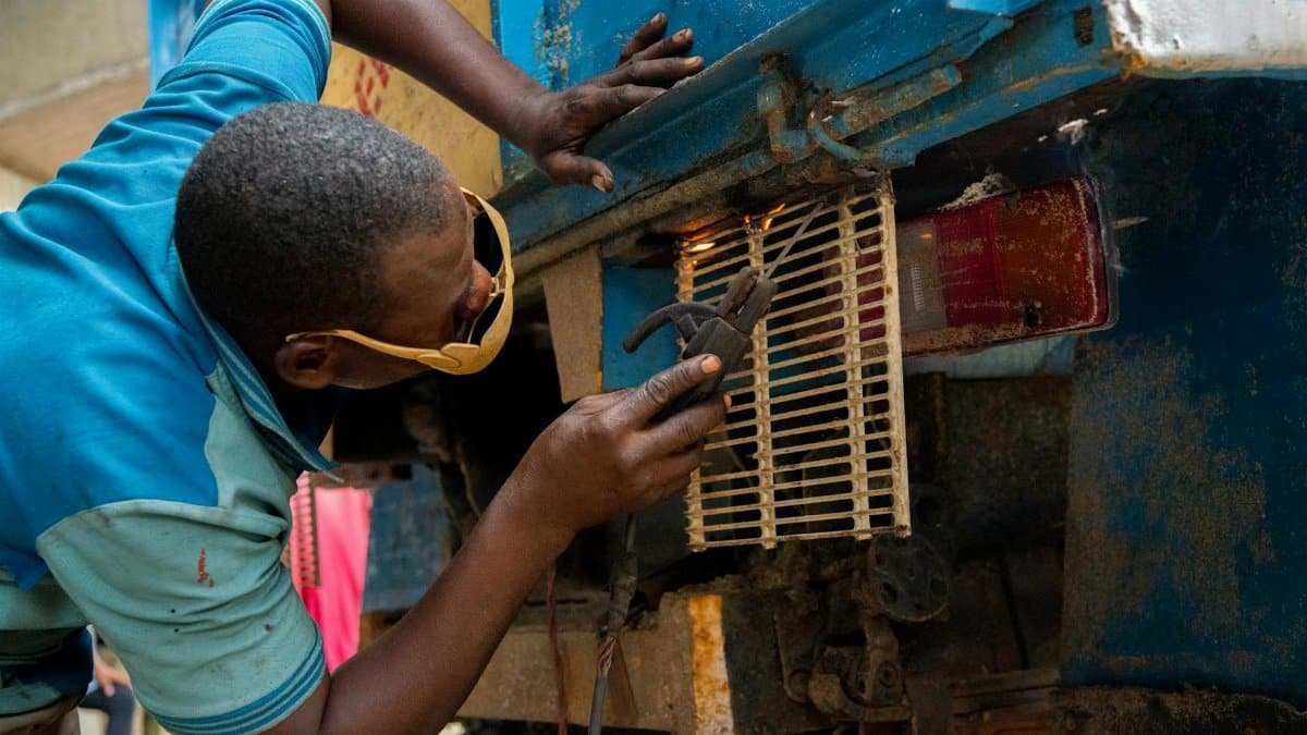 Skilled mechanic repairing a vehicle part in Lagos, reflecting hands-on industry work.