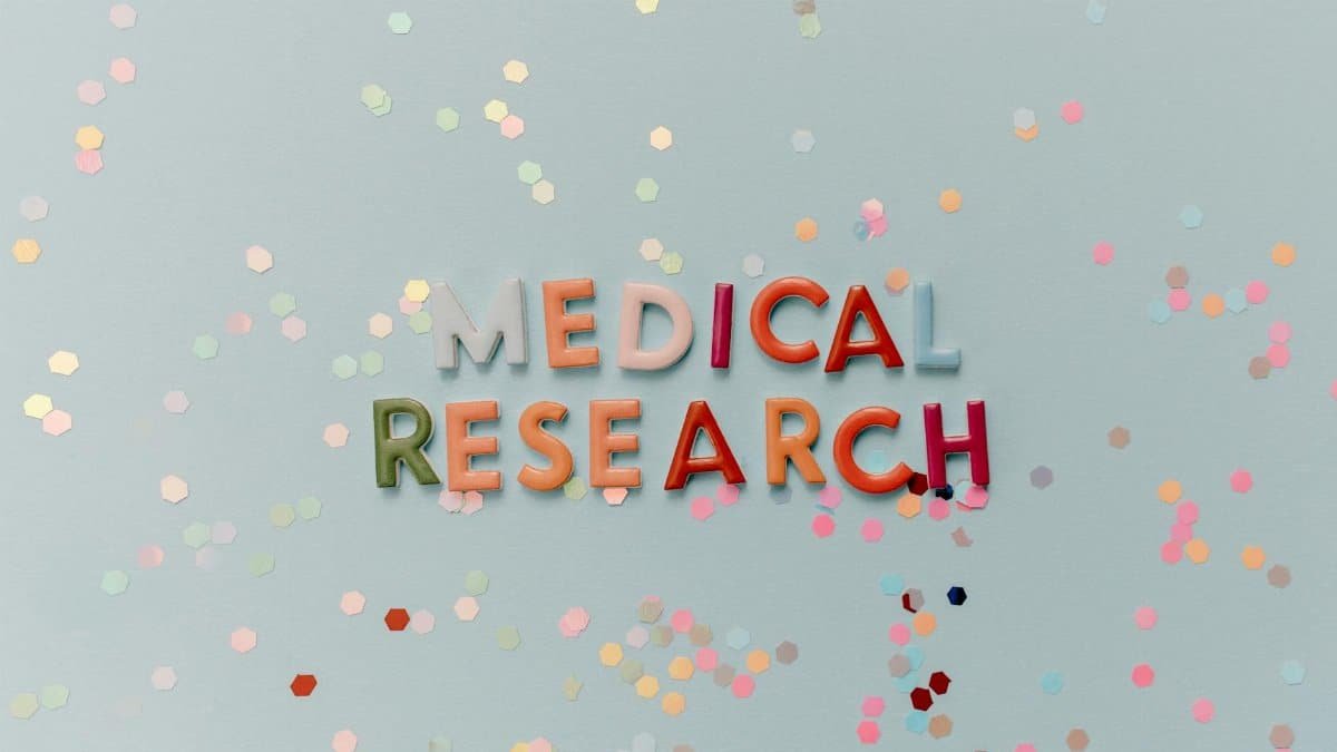 Colorful letters spell "Medical Research" against a confetti-strewn backdrop.