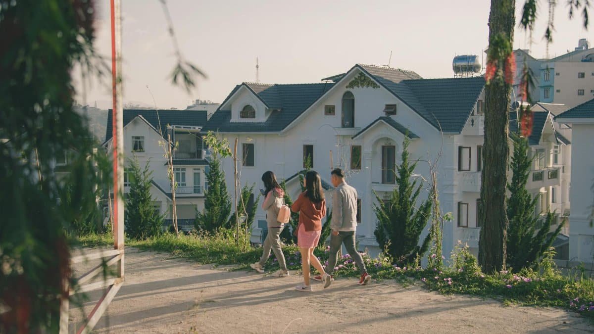 People walking along a paved path in a picturesque urban neighborhood with modern houses.