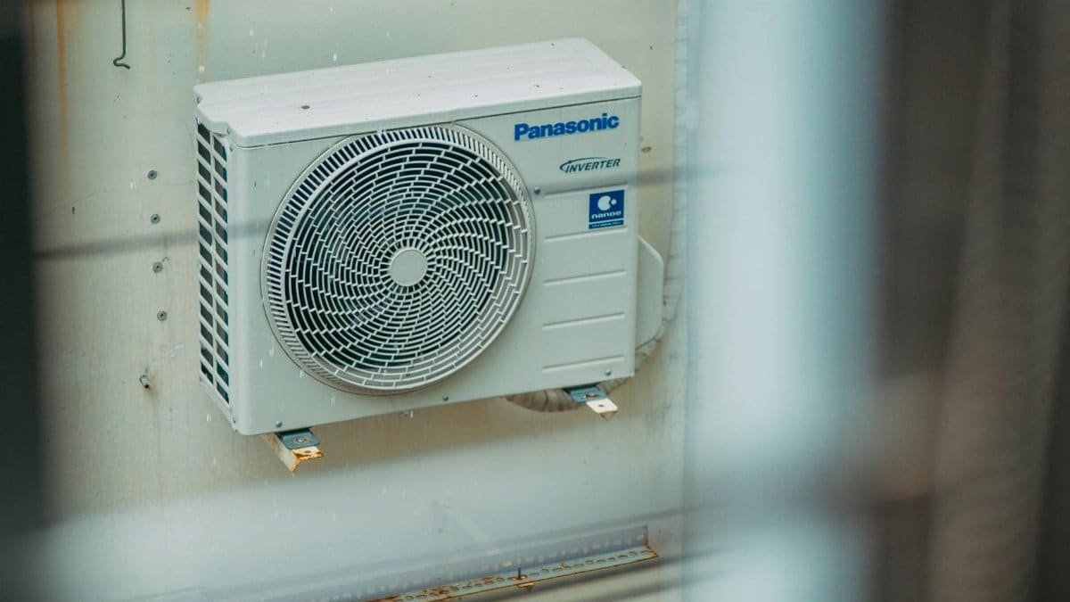 Air conditioner unit mounted outdoors on a building wall, showcasing modern HVAC technology.