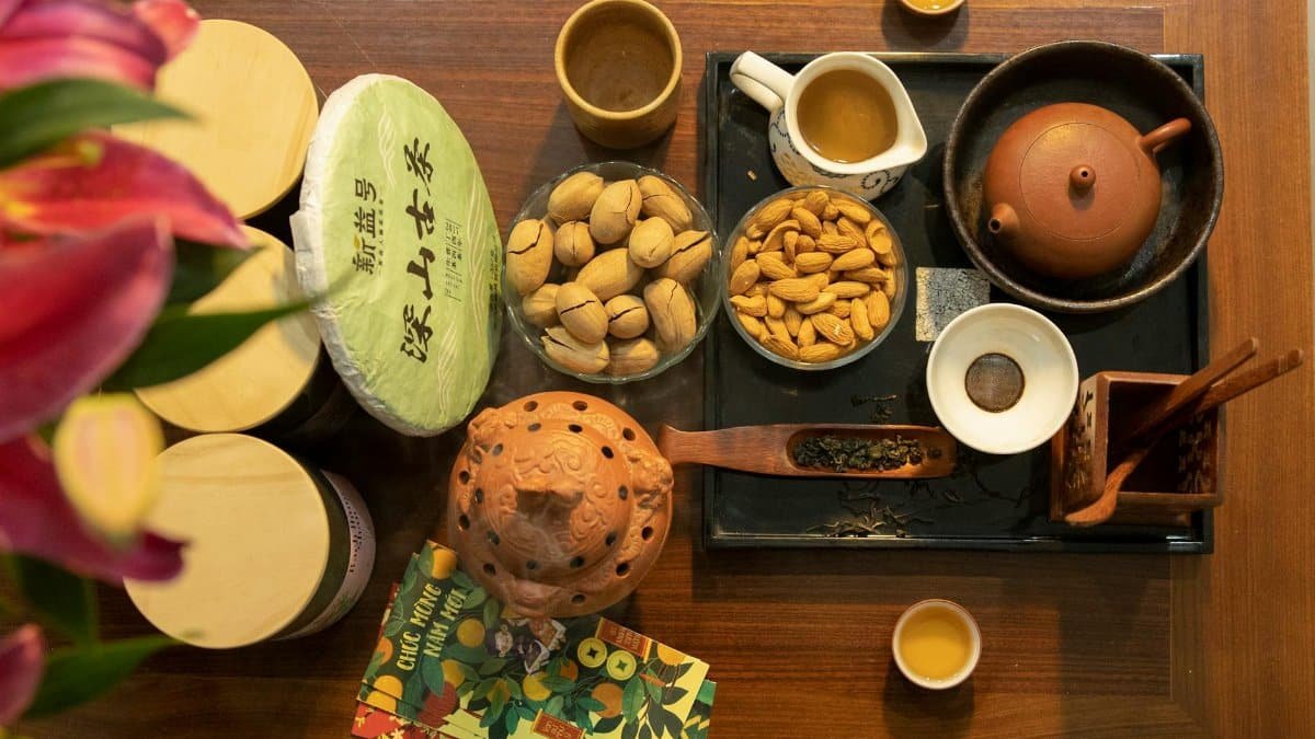 An overhead view of a traditional Chinese tea setting with almonds and nuts, creating a warm and inviting atmosphere.