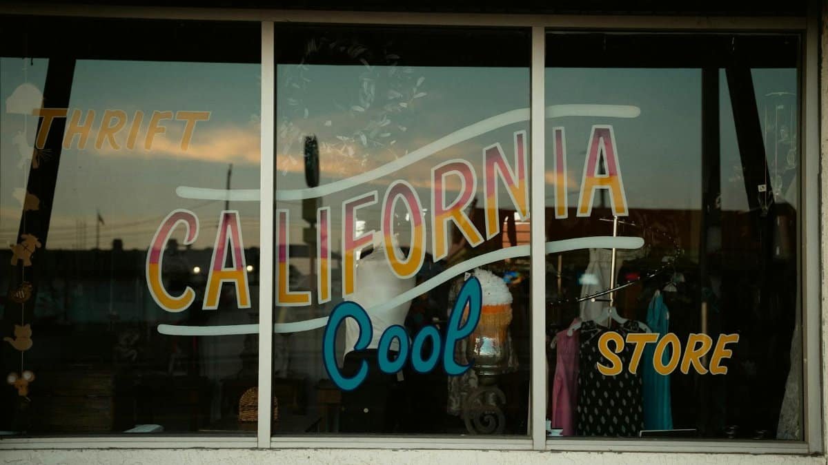 Vintage shop window with retro California thrift store signage and colorful display.