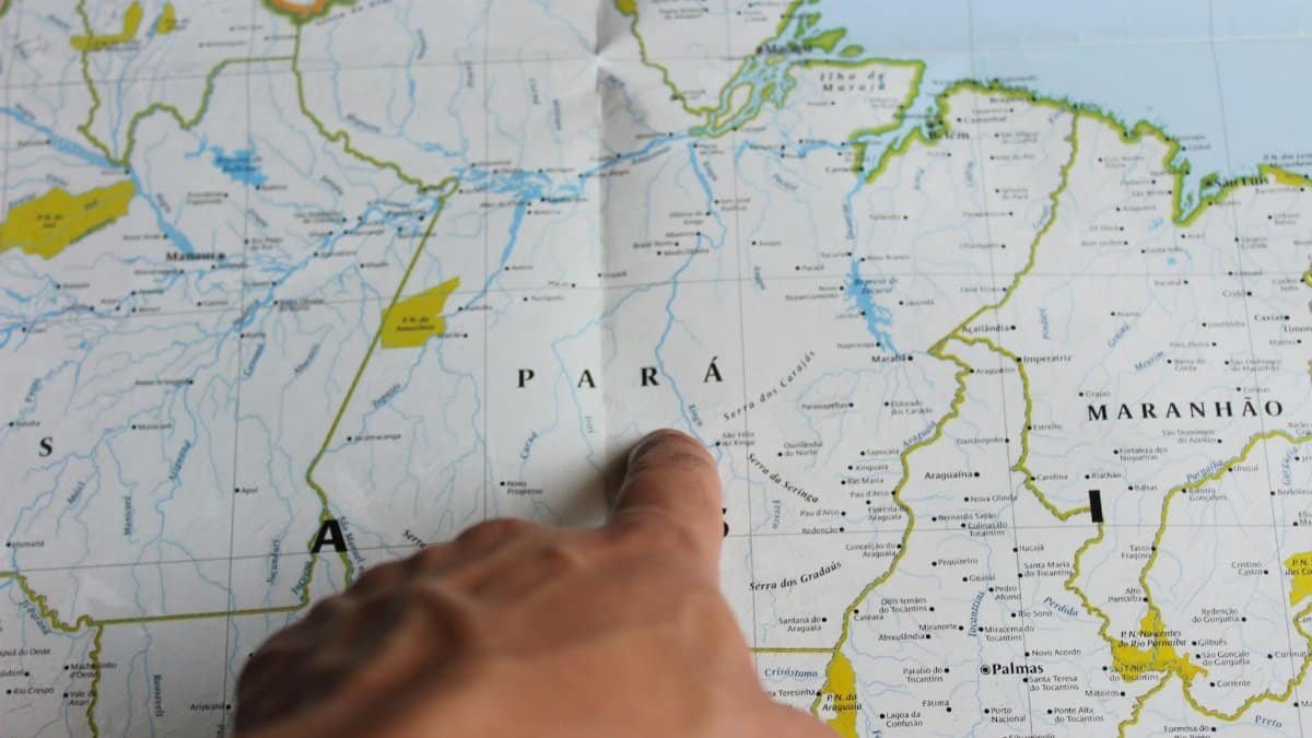 A close-up of a hand pointing at the state of Pará on a map of Brazil.
