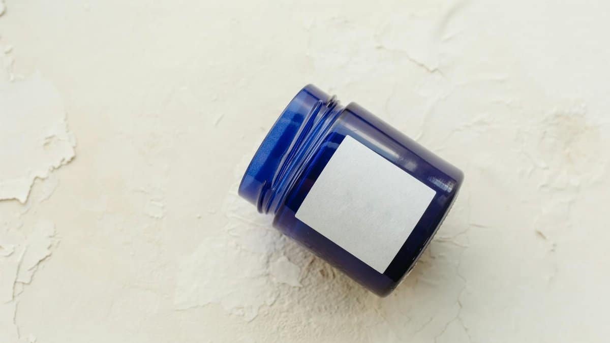 Simple blue container with label on a textured white background, perfect for mock-ups or product presentations.