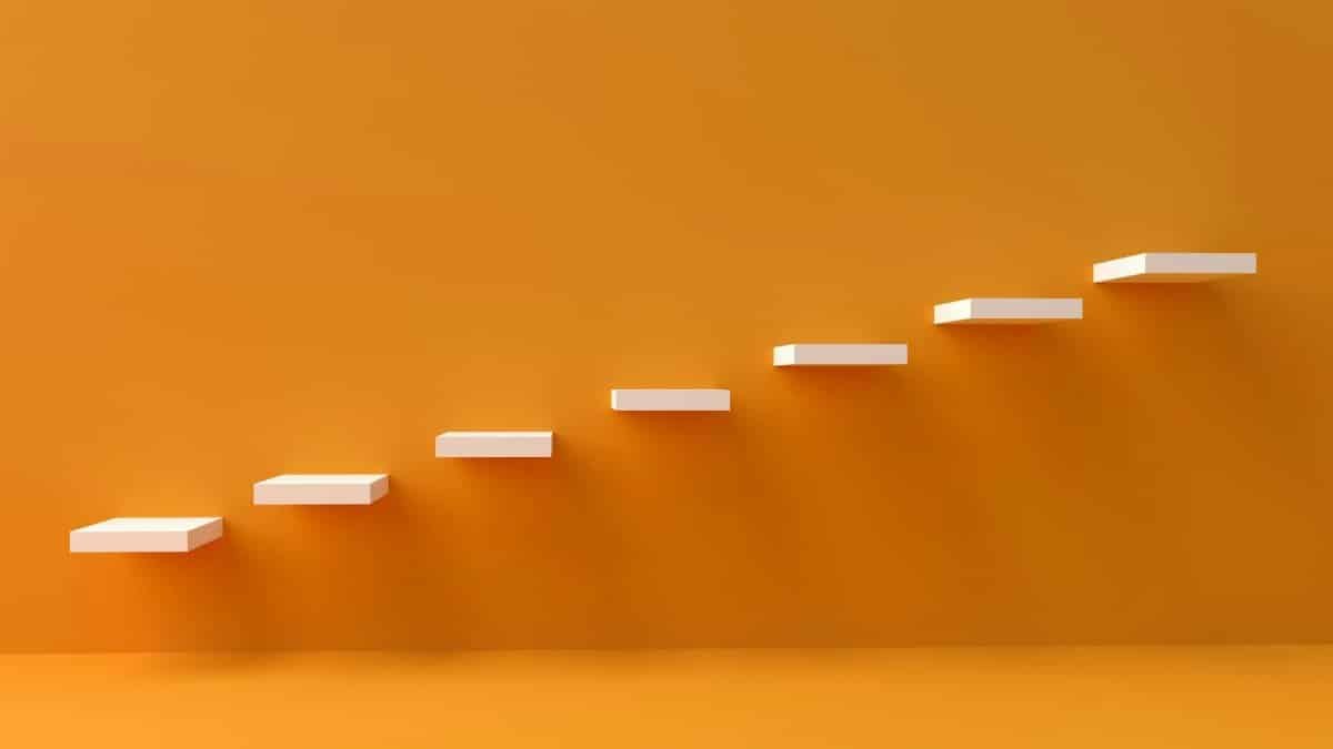 White floating steps on vibrant orange wall create a minimalist and conceptual design.