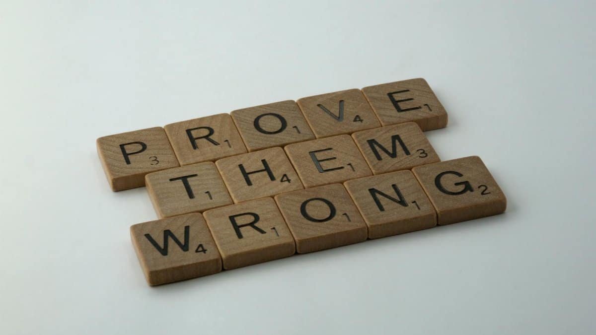 Scrabble tiles spelling the motivational phrase 'Prove Them Wrong' on a neutral background.