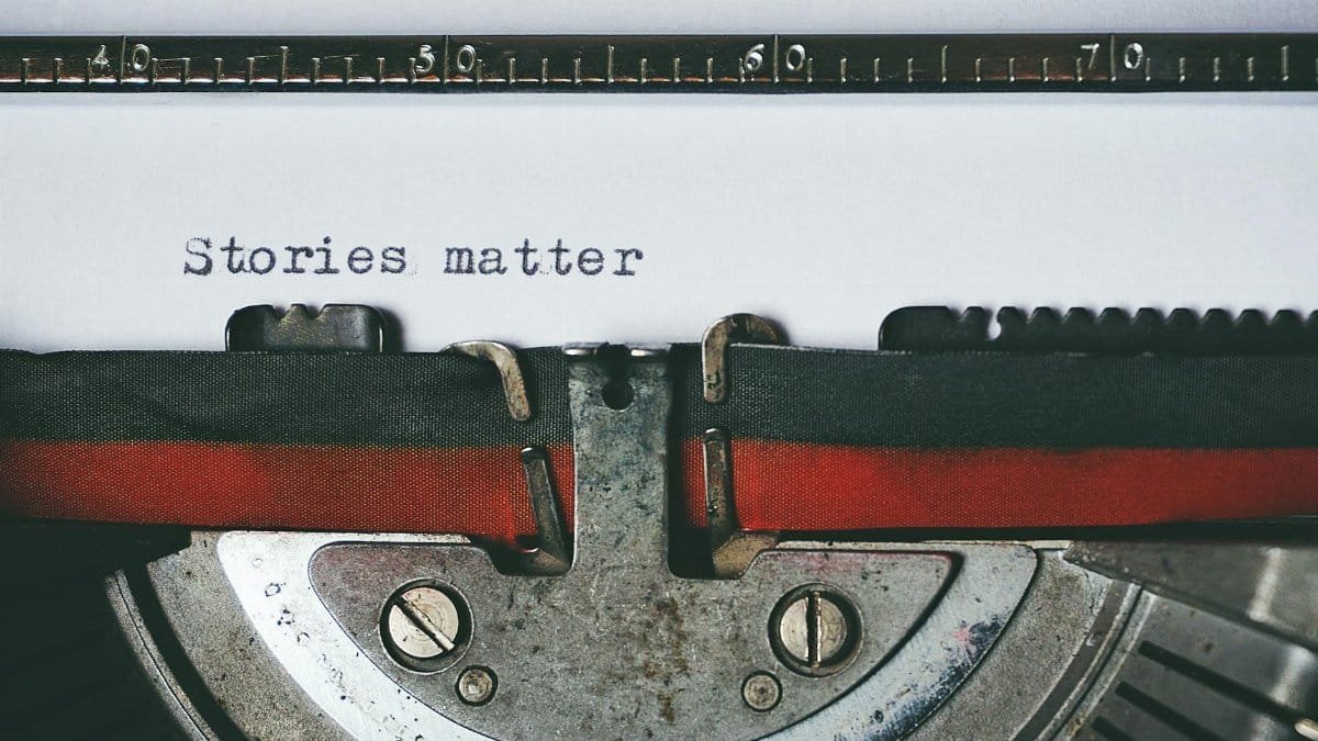 Close-up of a vintage typewriter with the text 'Stories matter' typed on paper, evoking nostalgia.