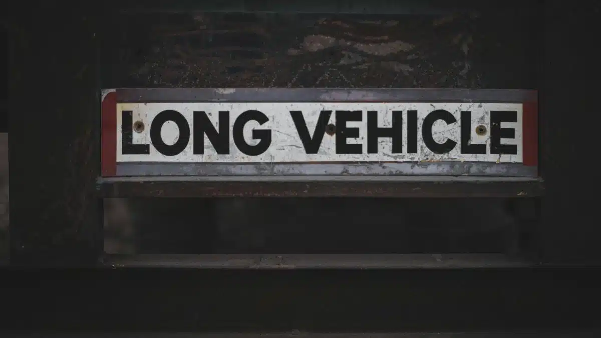 Detailed close-up of a 'Long Vehicle' sign on a metal structure, showcasing industrial signage.
