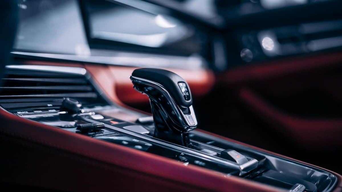Close-up of a sleek automatic gear shift in a luxury car interior.