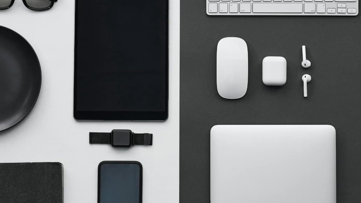 Stylish flatlay of modern tech gadgets including tablet, smartphone, smartwatch, and accessories.