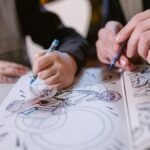 Child and an adult coloring a biker image in a coloring book, using crayons.