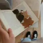 Top-view flatlay of dried autumn leaves in an old book, creating a rustic feel.