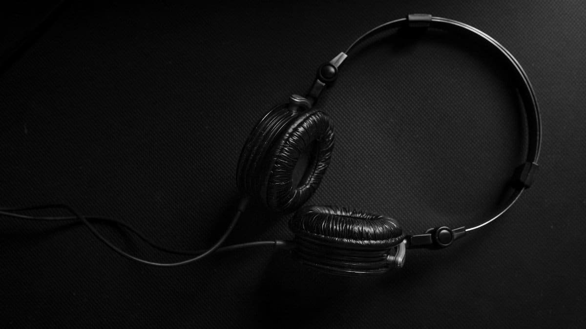 Minimalist black headphones on a dark textured background, ideal for audio and music design themes.