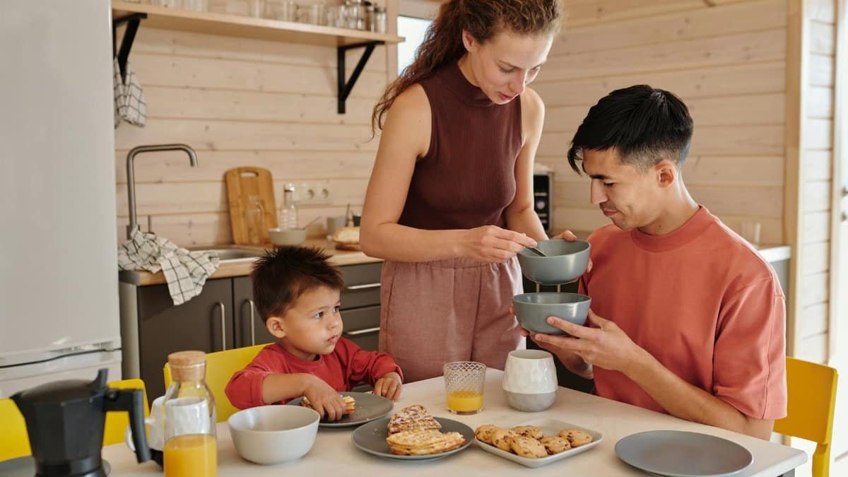 A happy family having breakfast together at home, sharing food and moments.