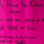 A vibrant protest sign in South Kingstown, Rhode Island, advocating against monarchies with political messaging.