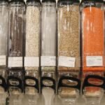 Row of eco-friendly bulk food dispensers in a shop promoting zero waste shopping.