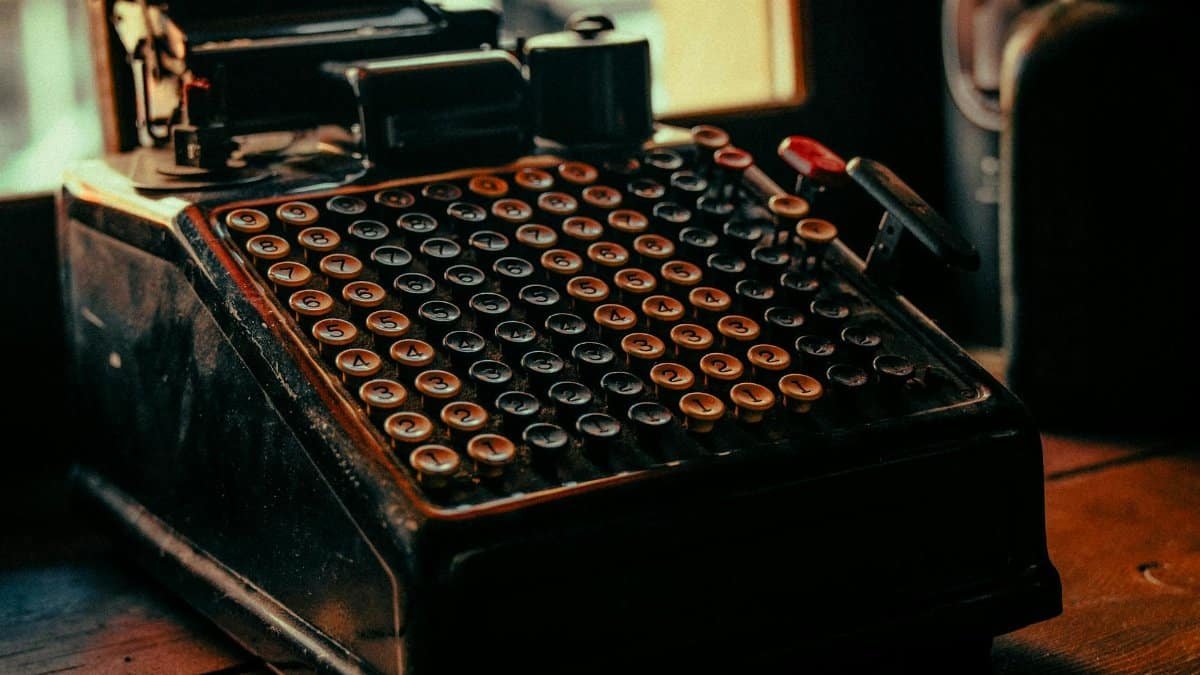A close-up view of a retro adding machine with numeric keys in a warm, nostalgic setting.