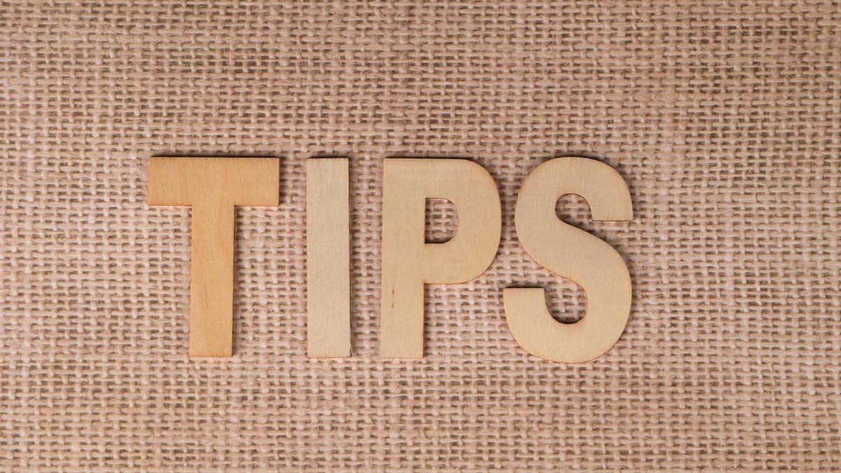 The word 'TIPS' in wooden letters on a burlap background, ideal for business advice visuals.