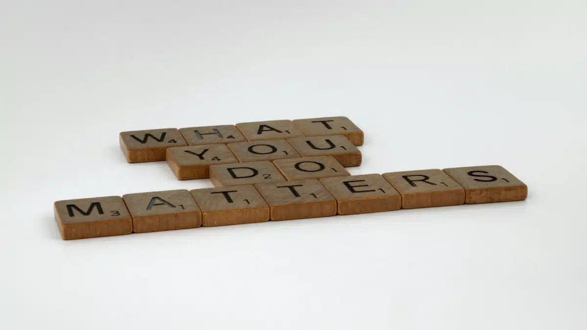 Scrabble tiles form the motivational phrase 'What You Do Matters' on a white background.