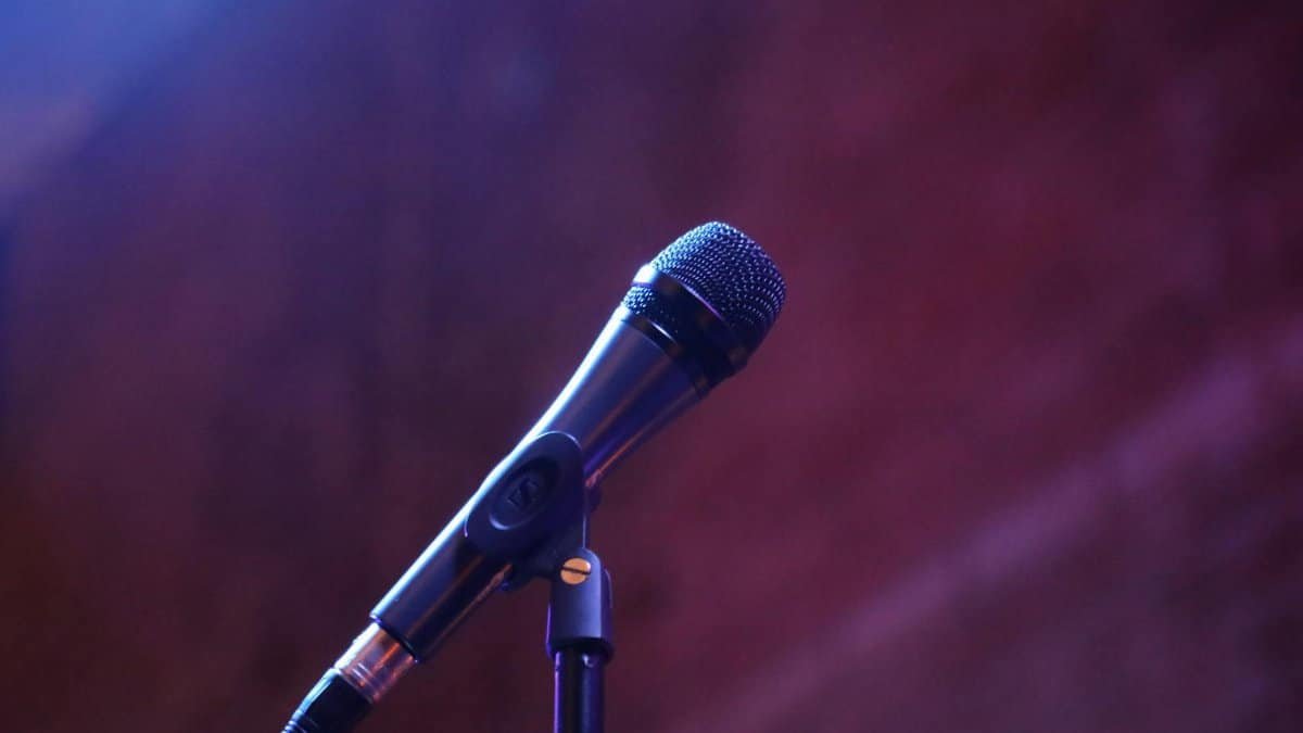 A microphone on a stand against a blurred background, perfect for music or event themes.