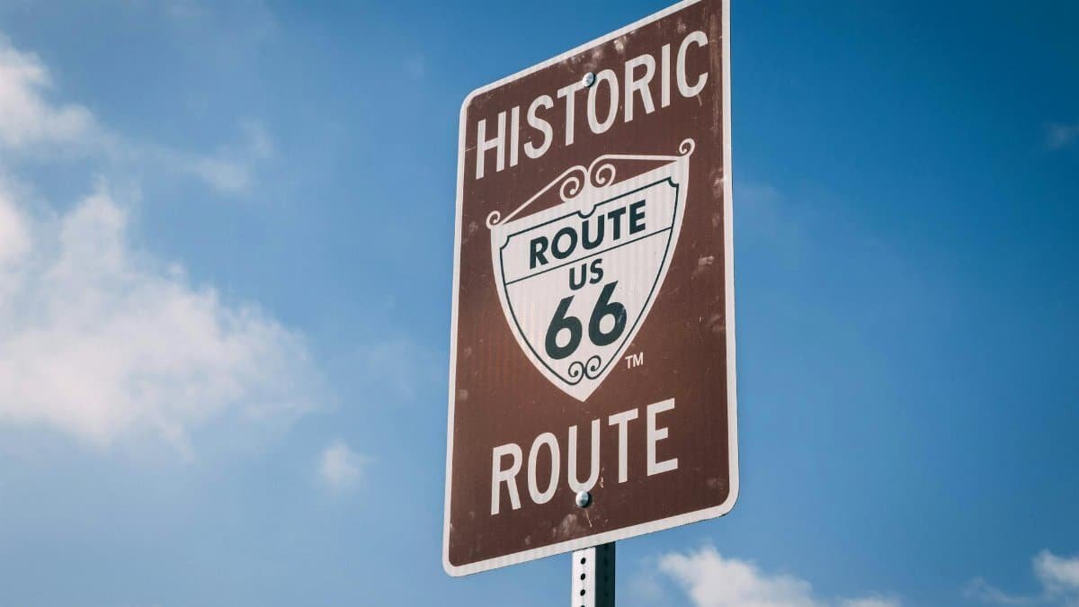 A classic Route 66 sign on a clear day, representing American road trip culture.