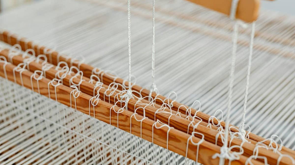 Detailed view of a wooden weaving loom with threads, showcasing traditional craftsmanship.