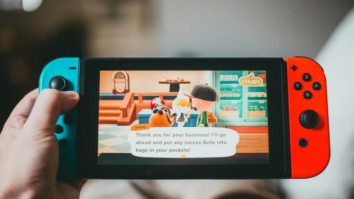 Crop anonymous person playing videogame while using game console and sitting at home on blurred background