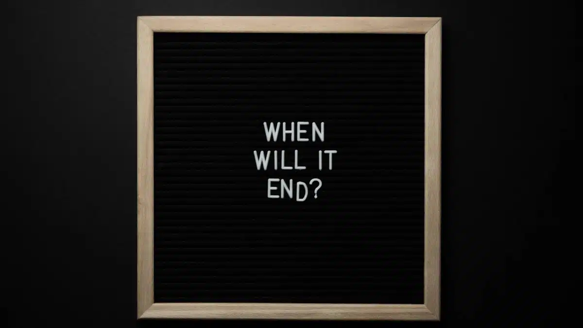 From above of chalkboard with When Will It End inscription on black background