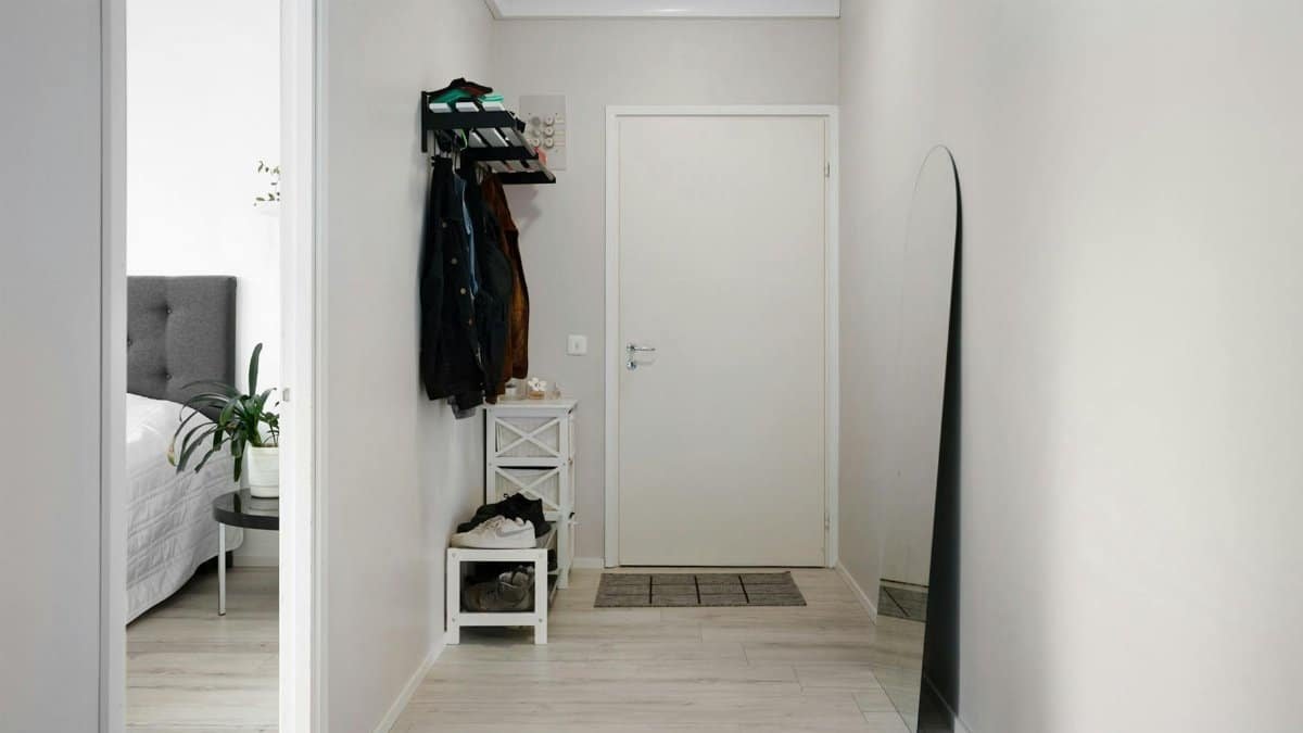 A minimalist hallway with white walls, modern decor, and simple furnishings.