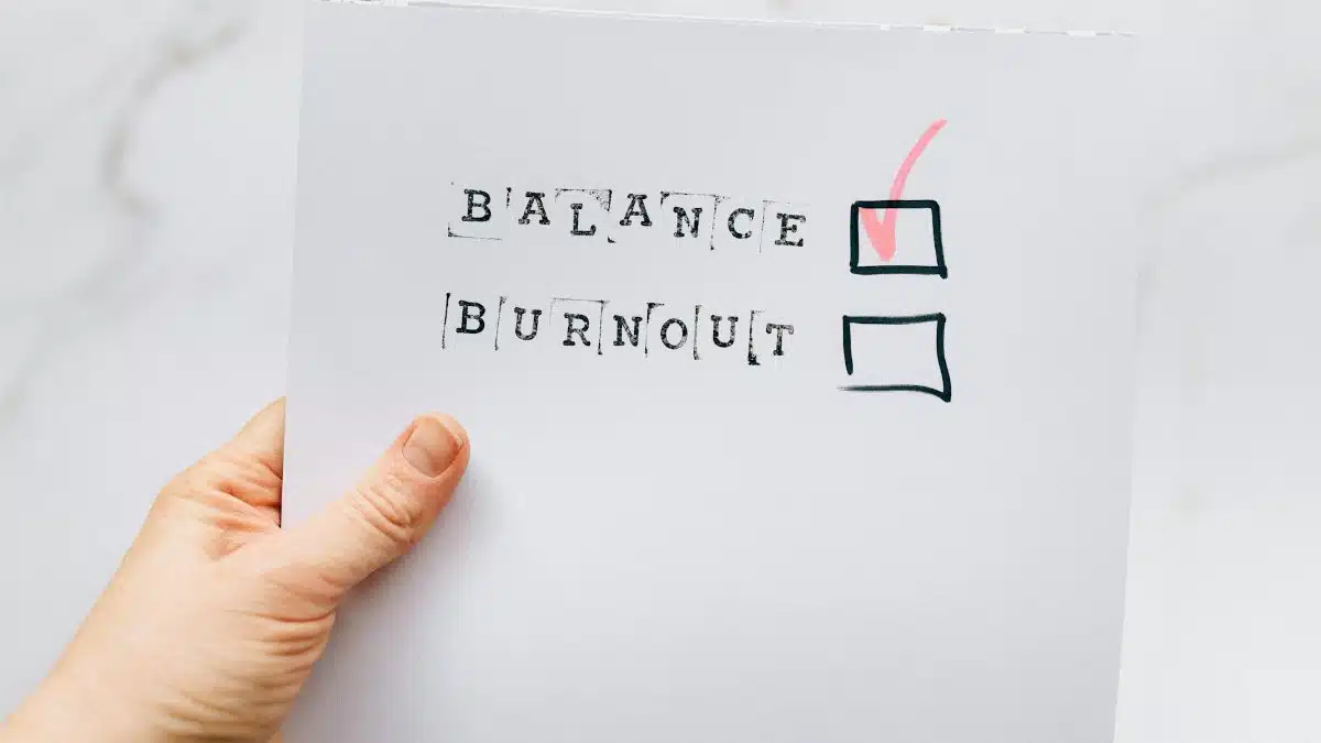 A hand holding a checklist highlighting the choice of balance over burnout, emphasizing mental health awareness.